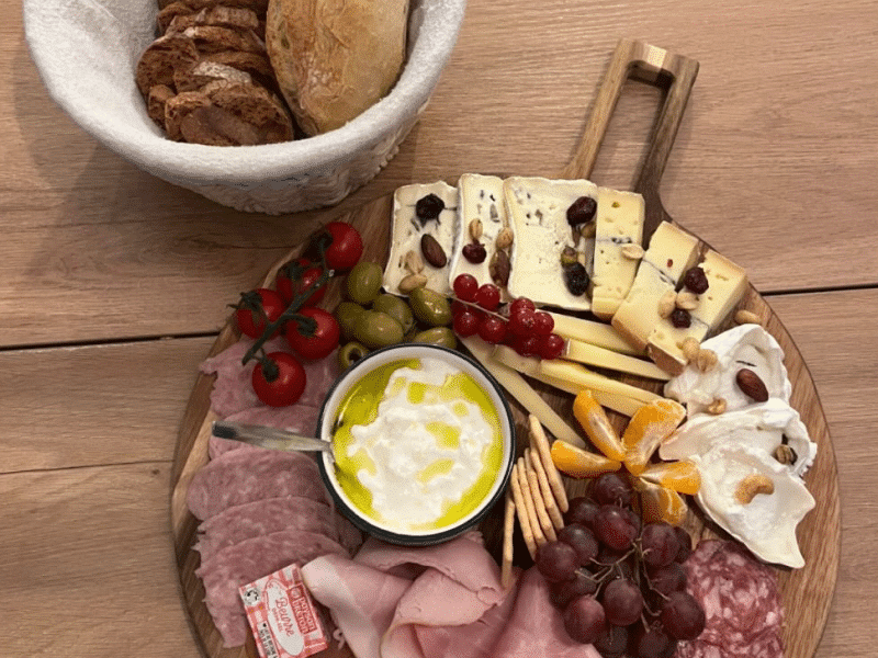 Plateau de charcuterie et fromages, idéal pour un séjour en gîte chaleureux.