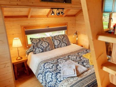 Chalet en bois cosy avec lit douillet et décoration chaleureuse en Auvergne-Rhône-Alpes.