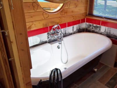 Salle de bain dun hébergement insolite en Auvergne-Rhône-Alpes avec baignoire élégante.