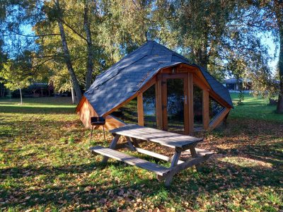 Cabane insolite en Auvergne, toit en ardoise et terrasse en bois. Nature environnante.
