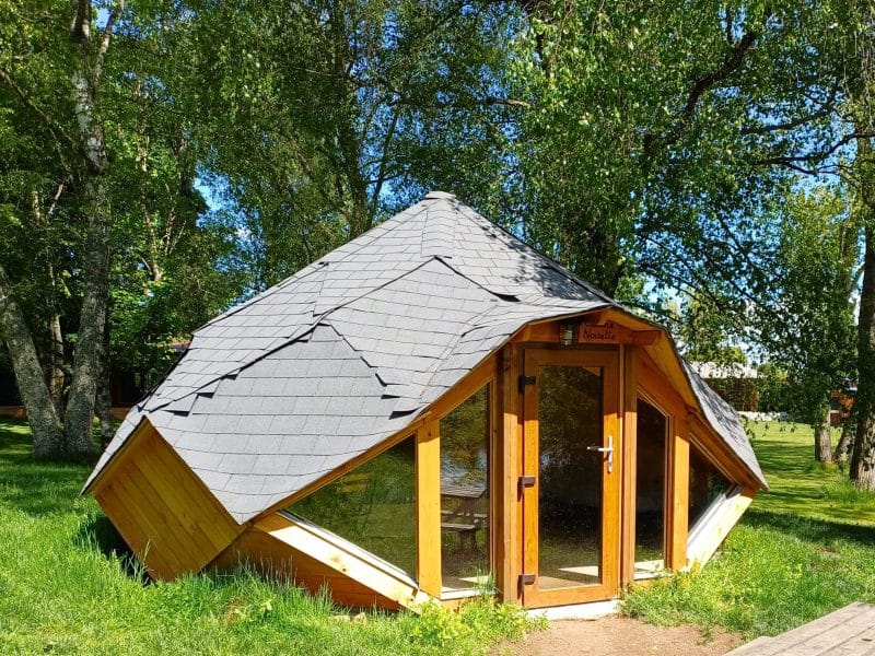 Hébergement insolite en Auvergne : cabane originale avec toit pentu et grandes fenêtres.
