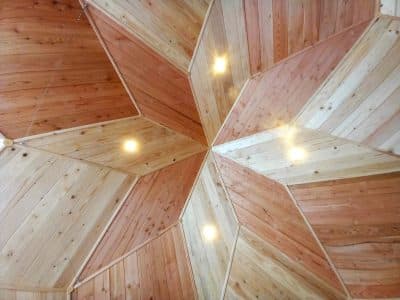Intérieur dun hébergement insolite en Auvergne, plafond en bois aux motifs géométriques.