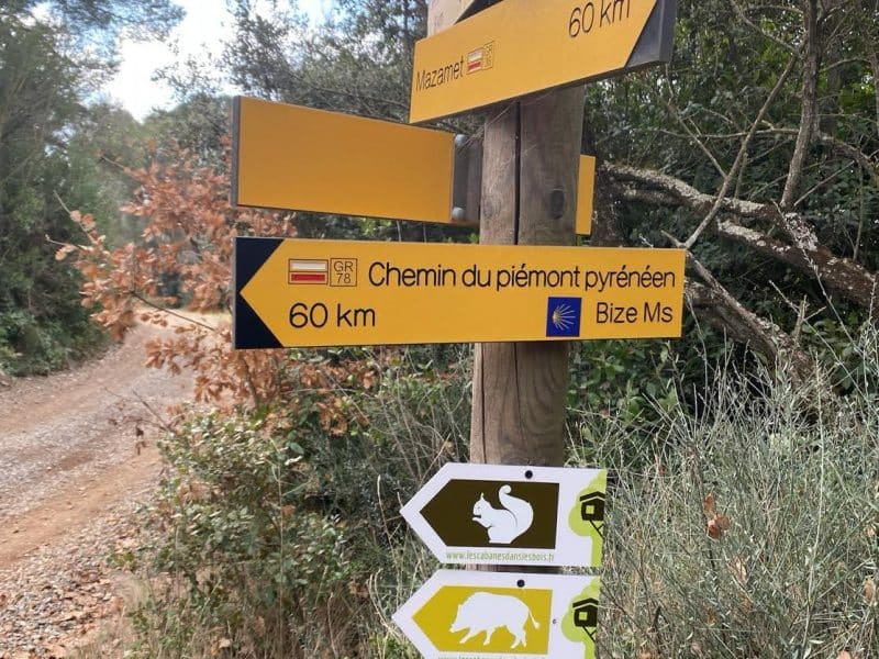 Hébergement en pleine nature, avec panneaux indicateurs colorés et sentiers pittoresques.