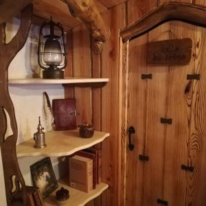 Hébergement insolite en bois en Nouvelle-Aquitaine, avec une porte sculptée et étagères.