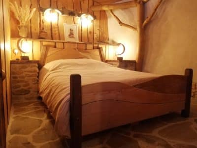 Chambre en bois dans un hébergement insolite, ambiance chaleureuse et rustique.