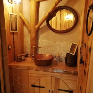 Salle de bain en bois dans un hébergement insolite en Nouvelle-Aquitaine. Éléments rustiques.