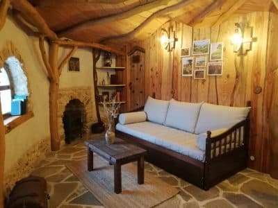 Cocon en bois en Nouvelle-Aquitaine, intérieur chaleureux avec pierres et lumière douce.