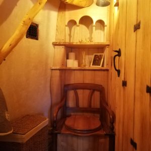 Hébergement insolite en Nouvelle-Aquitaine : coin chaleureux avec fauteuil en bois et décor naturel.