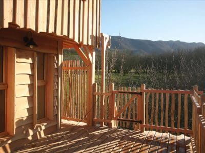 Cabane en bois avec terrasse, vue sur les montagnes en Auvergne-Rhône-Alpes.