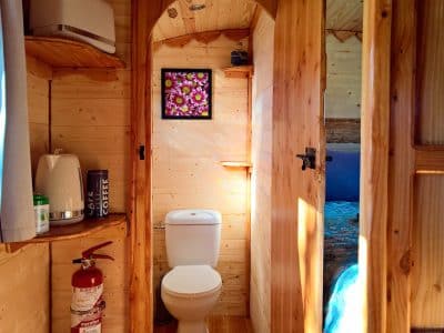 Hébergement insolite en bois en Auvergne-Rhône-Alpes, avec coin toilette et décoration florale.