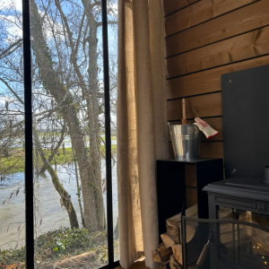 Chalet moderne avec vue sur la rivière et poêle à bois chaleureux.