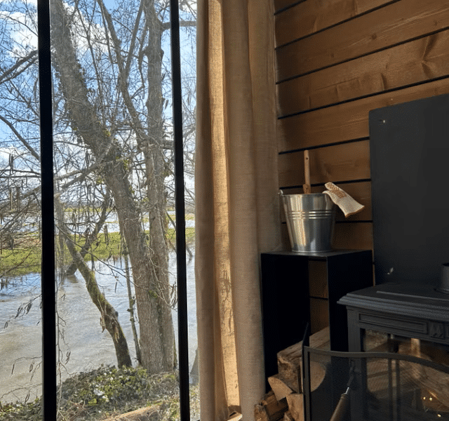 Chalet moderne avec vue sur la rivière et poêle à bois chaleureux.