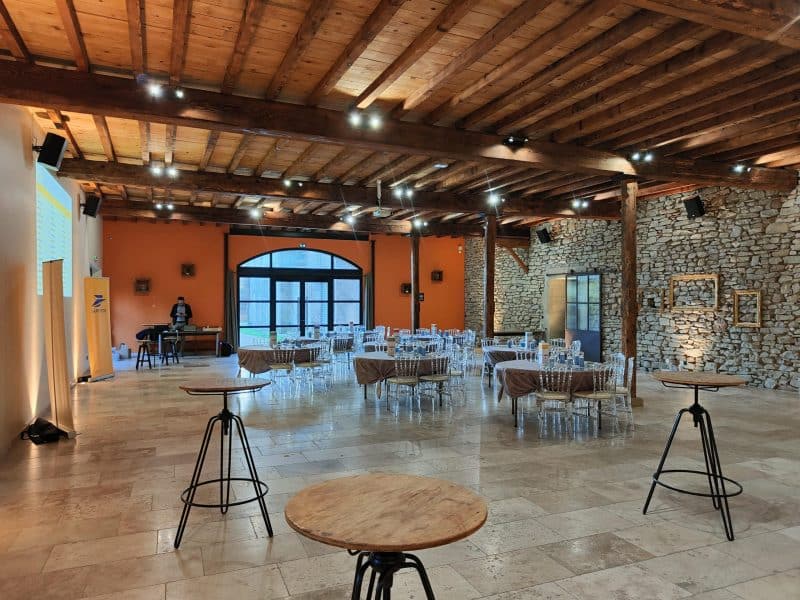 Salle de réception moderne avec murs en pierre et tables élégantes. Idéal pour événements.