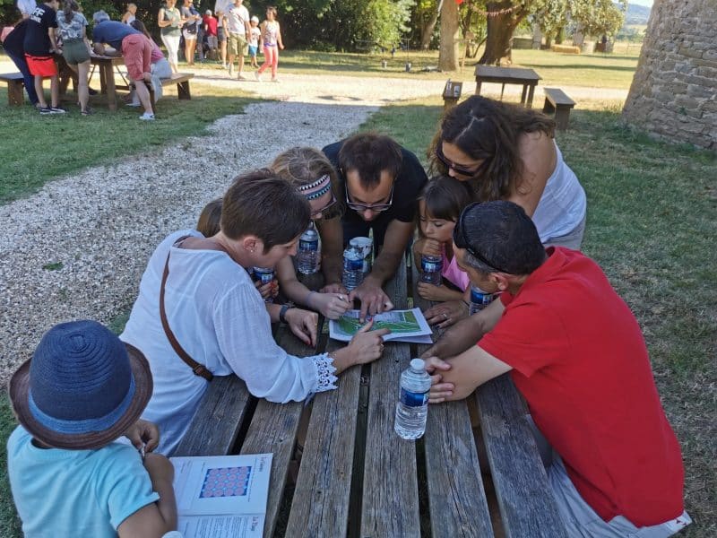 Groupe de familles en pleine activité ludique près dun gîte rural en plein air.
