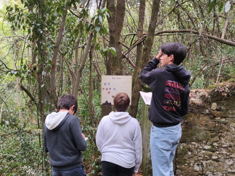 Trois enfants explorent un sentier forestier près dun hébergement en pleine nature.