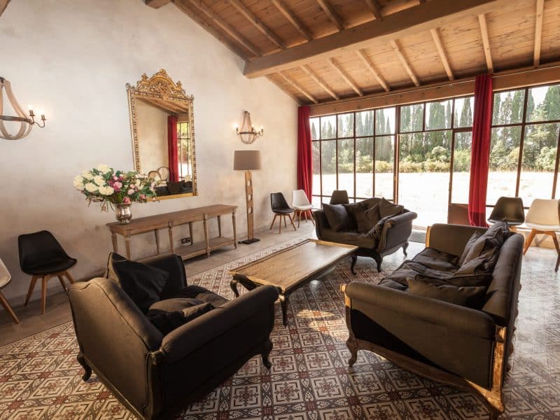 Salon dune maison de campagne, avec des fauteuils confortables et de grandes fenêtres.