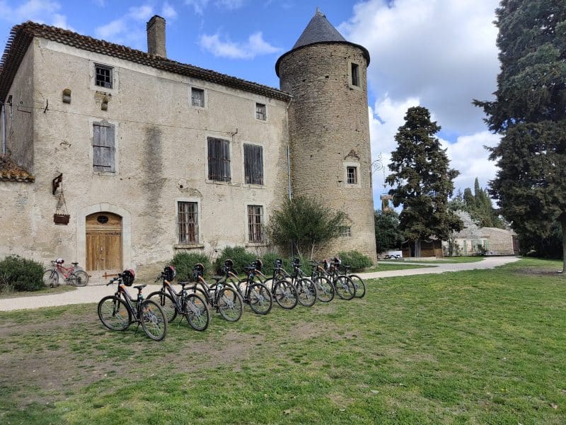 Château rustique avec vélos alignés sur la pelouse verdoyante.