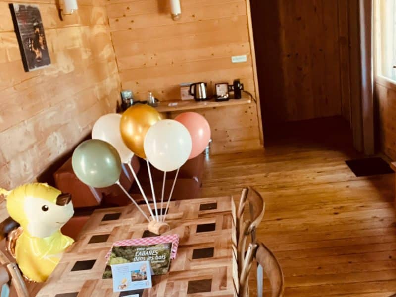 Chalet en bois chaleureux avec décorations danniversaire et ballons colorés.
