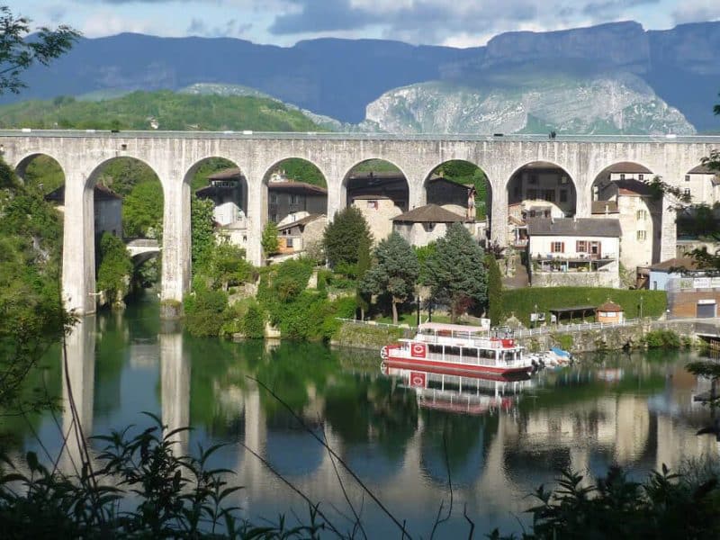 Charmant hôtel au bord de leau, avec un pont majestueux en arrière-plan.