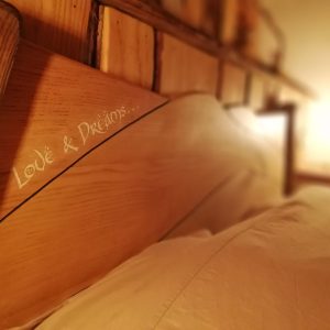 Hébergement insolite en Nouvelle-Aquitaine : lit en bois chaleureux avec lumière douce.