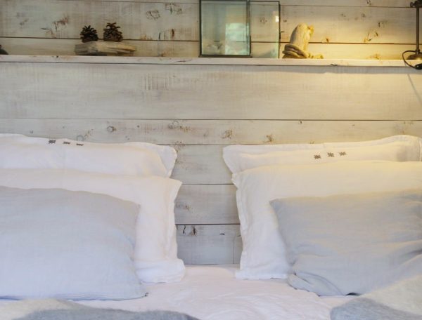 Chambre cosy en bois avec lit douillet et éclairage chaleureux.