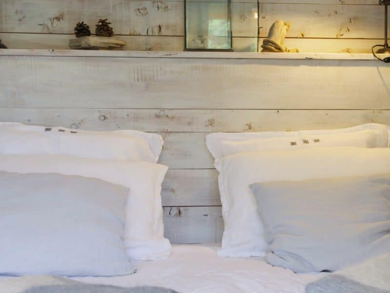 Chambre cosy en bois avec lit douillet et éclairage chaleureux.