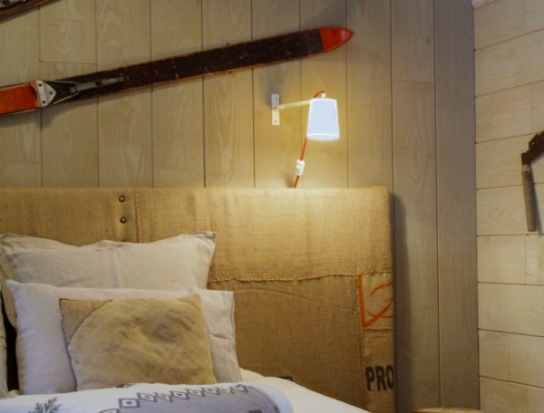 Chambre cosy en chalet, décorée avec des skis vintage et une literie douillette.