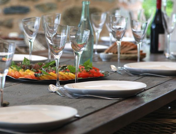 Table conviviale dans un gîte, décorée de plats colorés et de verres élégants.