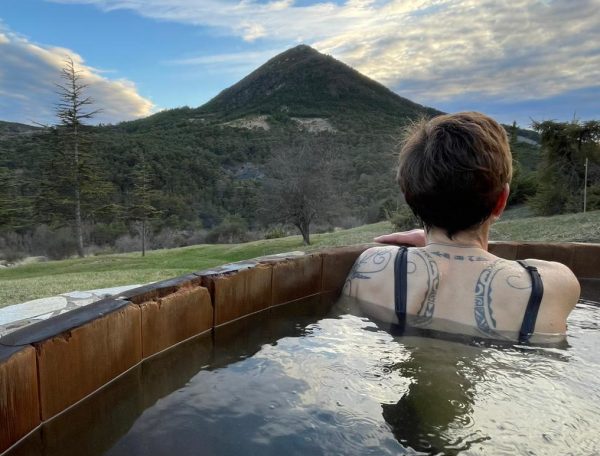 Hébergement en pleine nature avec baignoire extérieure, vue sur la montagne.