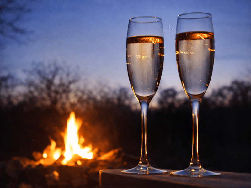 Flûtes de champagne et feu de bois au crépuscule