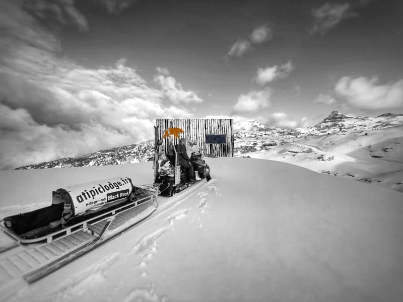 Hébergement en igloo, entouré de neige, avec un paysage montagneux spectaculaire.