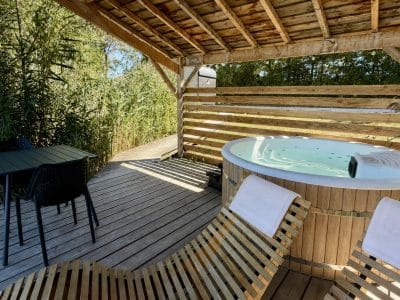 Hébergement insolite en Auvergne-Rhône-Alpes avec jacuzzi et terrasse en bois.