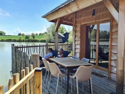 Cabane sur pilotis au bord de leau, terrasse en bois avec vue sur le lac.